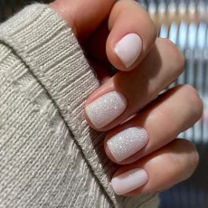 A set of 24 square false nails in a simple white French glitter design. These fake nails are full cover and can be easily removed. Buy them in bulk at a wholesale price.